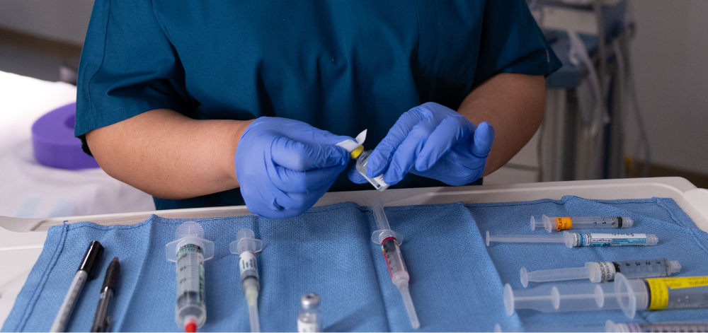 CRNA preparing medication for anesthesia in the operating room