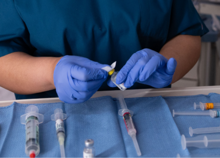 CRNA preparing medication for anesthesia in the operating room
