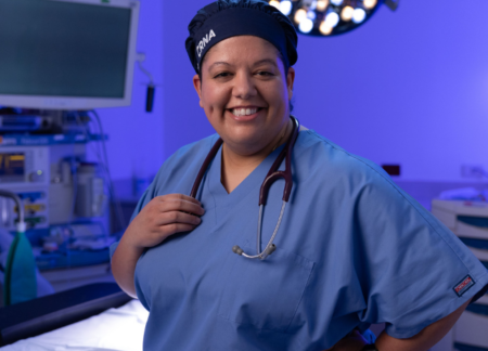 CRNA standing in the operating room smiling