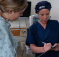 CRNA with a female patient at the bedside before surgery