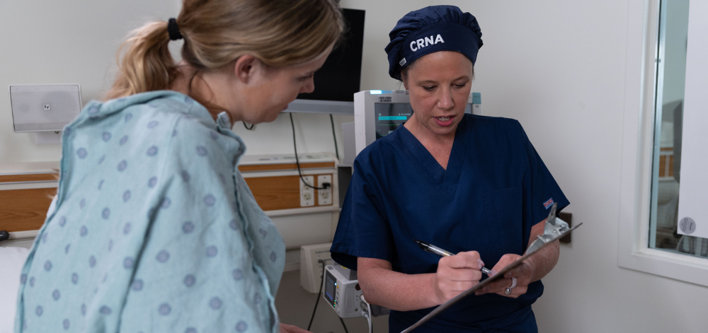 CRNA with a female patient at the bedside before surgery
