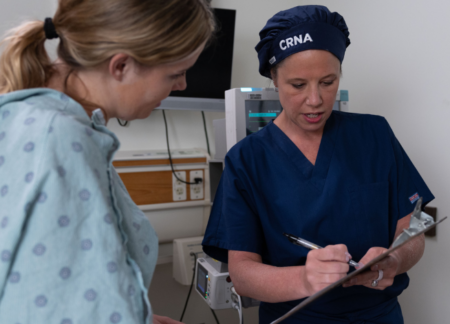 CRNA with a female patient at the bedside before surgery