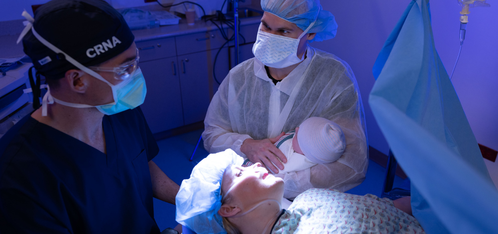 CRNA with newborn and parents after a c-section