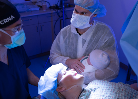 CRNA with newborn and parents after a c-section