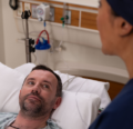 CRNA explaining procedure to a patient in bed