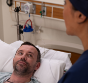 CRNA explaining procedure to a patient in bed