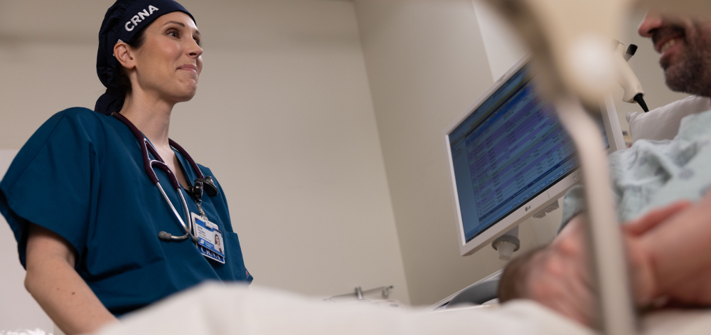 CRNA talking with a patient in bed