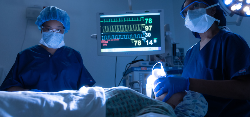 CRNA administering anesthesia in an OR with an assistant