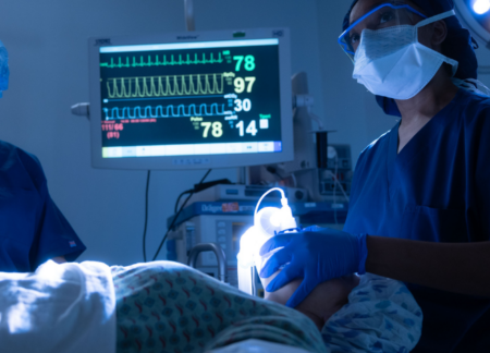 CRNA administering anesthesia in an OR with an assistant