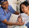 Parent with child and CRNA before surgery