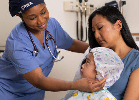 Parent with child and CRNA before surgery