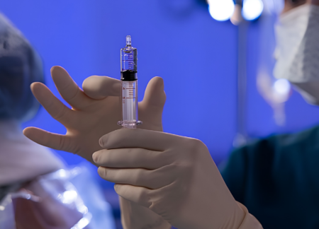 CRNA prepping syringe in OR