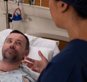 CRNA speaking to man at bedside