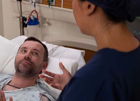 CRNA speaking to man at bedside