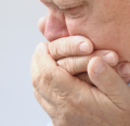 Man holding hands up to mouth