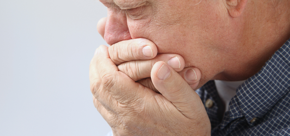 Man holding hands up to mouth