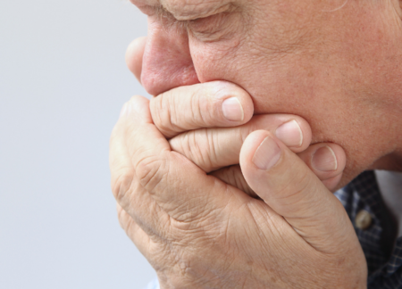 Man holding hands up to mouth