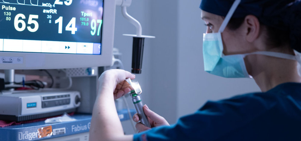 CRNA preparing to administer anesthesia to patient
